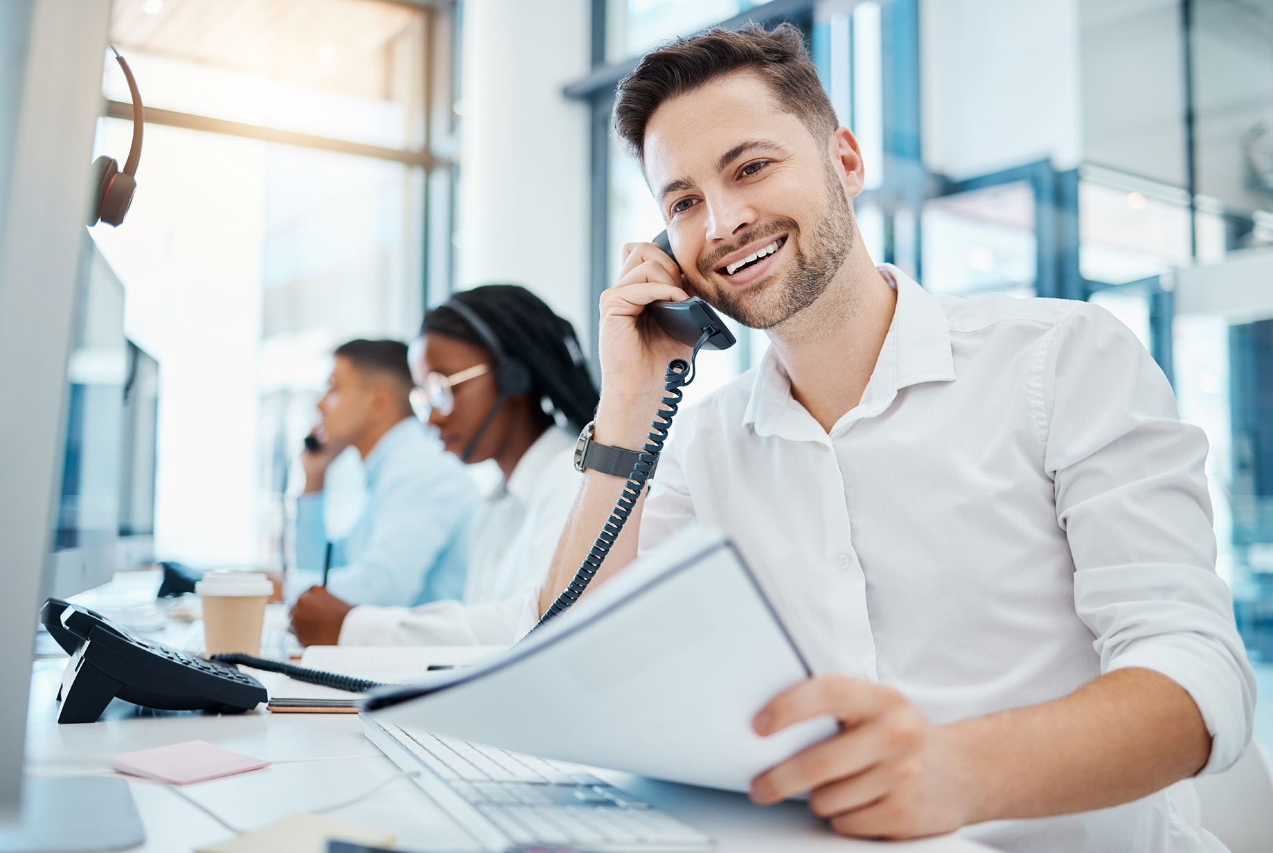Telemarketing, sales or customer service worker smiling and talking on a telephone selling insurance. Young happy call center agent excited by good news on the phone and working in an office Telemarketing, sales or customer service worker smiling and talking on a telephone selling insurance. Young happy call center agent excited by good news on the phone and working in an office